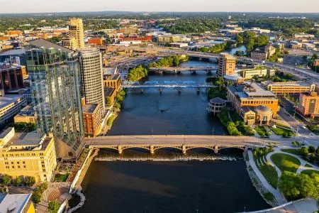 Aerial view of downtown buildings and bridges along a river at sunset