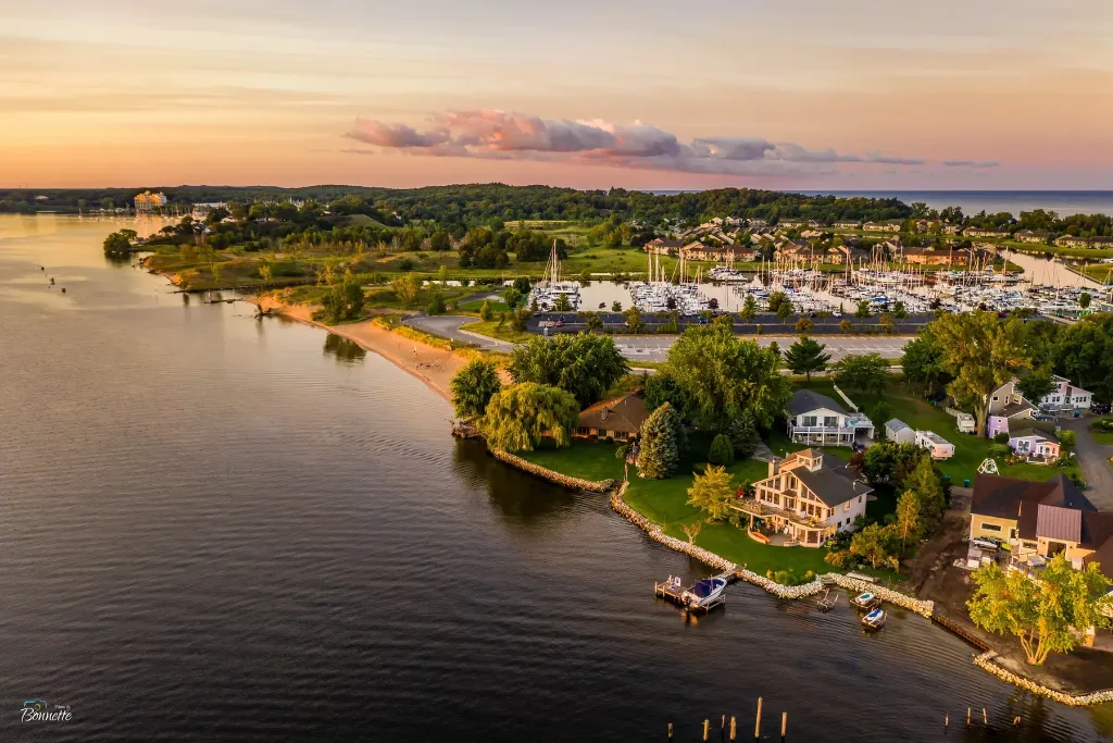 Aerial view of waterfront homes along a lake shoreline in Muskegon County, MI at sunset